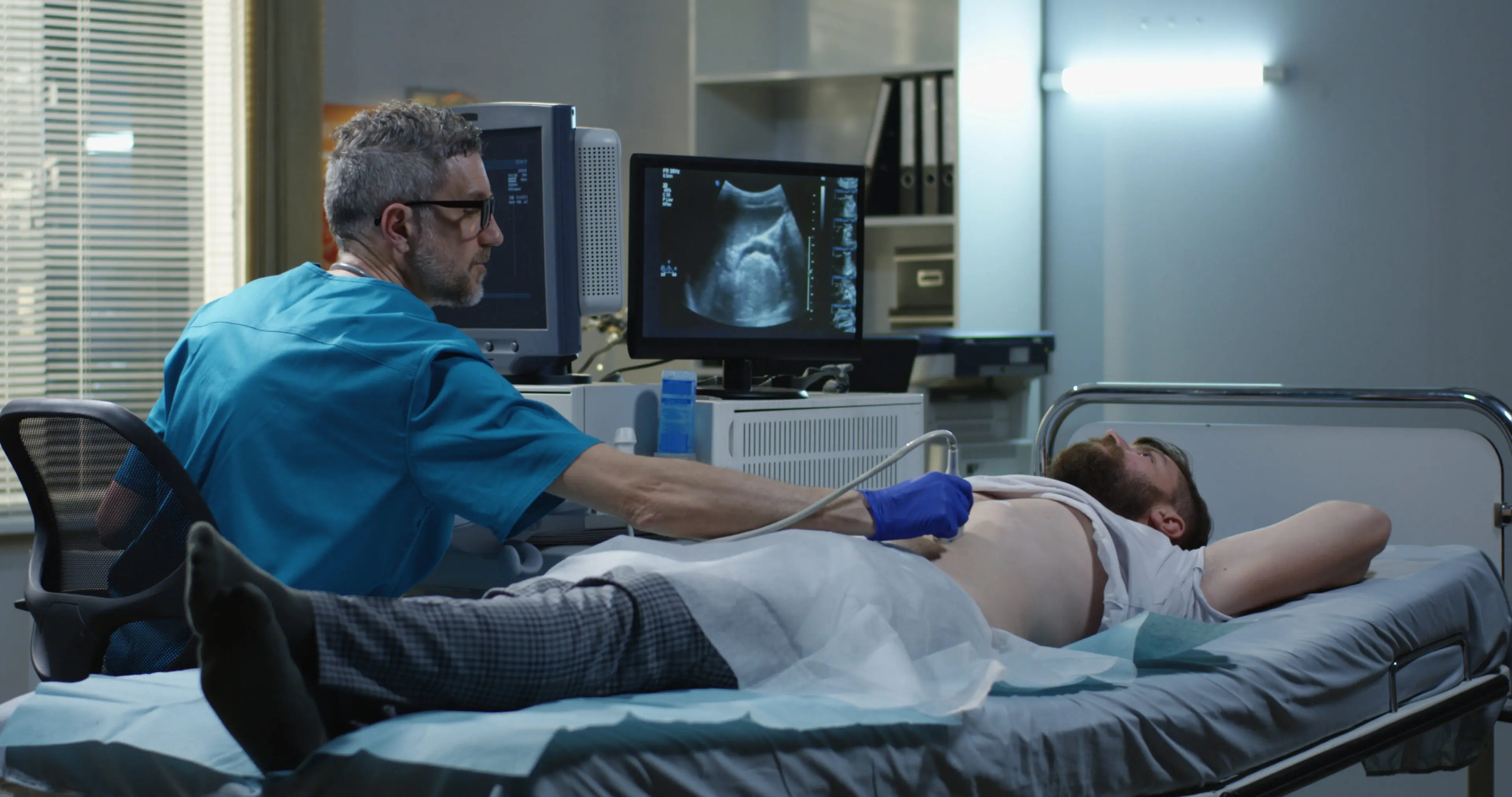 A doctor is performing an ultrasound on the stomach of a patient.